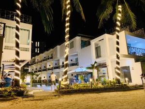 un hotel en la playa con palmeras y luces en Boracay Ocean Club Beach Resort, en Boracay