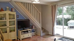 a living room with a tv and a staircase at villa OLERON in Chaucre