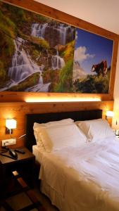 a bedroom with a large painting above a bed at Dada Mountain Hotel in Morgex