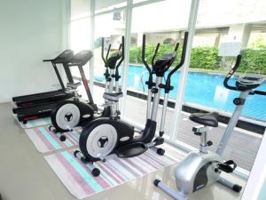 a gym with three exercise bikes and a swimming pool at P Park Residence Suvarnabhumi in Bangkok