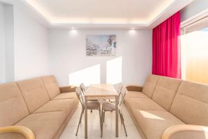 a room with a couch and a table and chairs at Apartamenty Flamingo by Renters in Międzyzdroje