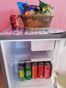 a refrigerator with a basket of chips and soda at Agimats Crib Palawan in Puerto Princesa City