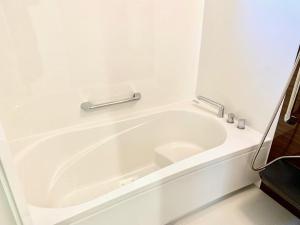 a white bath tub in a white bathroom at Shisa Terrace Ginoza in Ginoza +9 photos