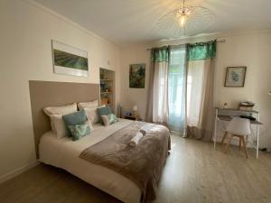 a bedroom with a large bed and a desk at Studio Clémenceau in Beaune