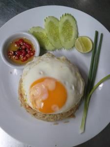a white plate with an egg and vegetables on it at Restaurant & Guesthouse Say Cheese in Hua Hin