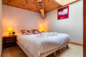 - une chambre avec un grand lit blanc et deux lampes dans l'établissement Résidence Le Cristal - Lognan 8 - Happy Rentals, à Chamonix-Mont-Blanc