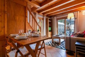 - une salle à manger en bois avec une table et un canapé dans l'établissement Résidence Le Cristal - Lognan 8 - Happy Rentals, à Chamonix-Mont-Blanc