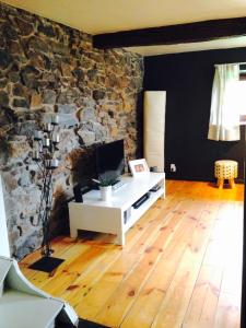 a living room with a stone wall and a desk at L'inspiration in Stavelot