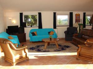 sala de estar con sofá azul y mesa en Oberes Ourtal Lodge, en Büllingen