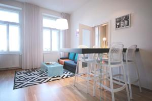 sala de estar con mesa y sillas en Modern Futuristic Apartment / Žižkov TV Tower + Metro Station en Praga