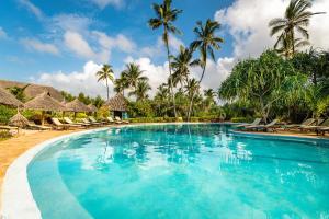 a swimming pool at a resort with palm trees at Zanzibar Queen Hotel in Matemwe