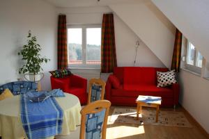 a living room with a red couch and a table at Ferienwohnung Seeberger in Friedrichshafen