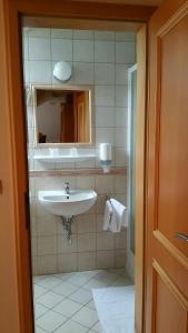 a bathroom with a sink and a mirror at Vadászkürt Panzió és Étterem in Sopron