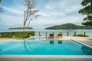 パナワビーチにあるNam Bo villa by Loftyの水辺の景色を望むスイミングプール