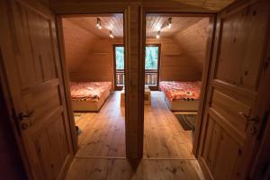 an attic room with two beds and two windows at Ekoma rezort in Zvolen