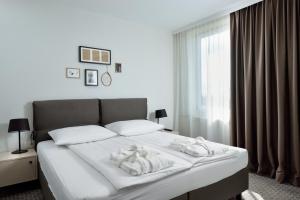 a white bed with a white comforter and pillows at B&B Hotel Ljubljana Park in Ljubljana