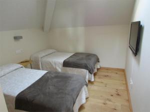 Zimmer mit 3 Betten und einem Flachbild-TV in der Unterkunft Posada Real El Brasilero in Saucelle