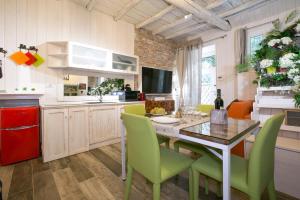 a kitchen and dining room with a table and green chairs at ROUTE 66 SPA in Vignanello
