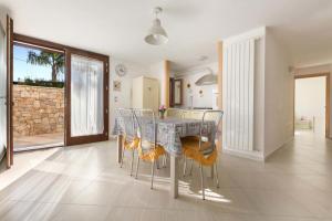 eine Küche und ein Esszimmer mit einem Tisch und Stühlen in der Unterkunft Dependance di Villa Melissa in Parabita