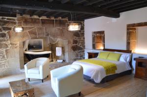 a bedroom with a bed and a stone wall at Reitoral de Parada in Parada del Sil