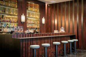 un bar con una fila di sgabelli in una stanza di Divani Caravel ad Atene Altre 37 foto