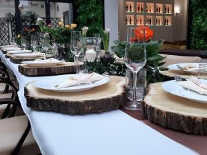 einem langen Tisch mit Tellern und Weingläsern auf Holz in der Unterkunft Hotel Litovel in Komárno