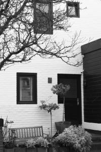 een wit huis met een bankje ervoor bij Appartement Lefferts in Zandvoort