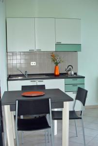 een keuken met een tafel, 2 stoelen en een aanrecht bij Tre ponti monolocale in Verbania