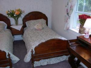 a bedroom with two beds with a stuffed animal sleeping on it at Antique Slumber Old Town Bed & Breakfast in Niagara-on-the-Lake