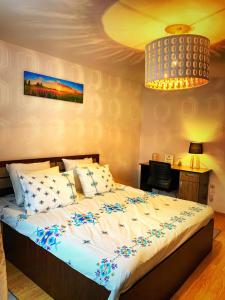 a bedroom with a large bed with blue flowers on it at Cozy Studio in Cugir