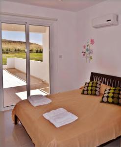 a bedroom with a large bed with towels on it at Family Apartment with Terrace in Pyla