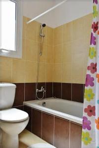 a bathroom with a toilet and a bath tub with a shower curtain at Family Apartment with Terrace in Pyla