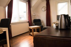 a living room with a table and two windows at Appartement Lefferts in Zandvoort