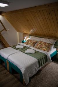 a large bed in a room with a wooden ceiling at Penzión Skorušina in Brezovica