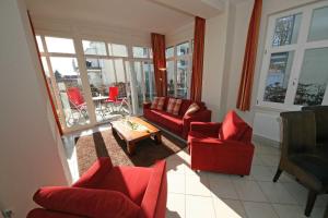ein Wohnzimmer mit Sofas, Stühlen und einem Tisch in der Unterkunft Haus Möwe I Whg 02 mit Terrasse in Ostseebad Sellin