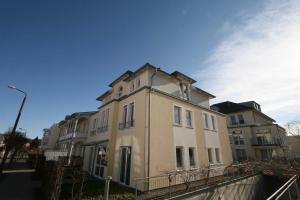 ein großes weißes Gebäude am Straßenrand in der Unterkunft Haus Möwe I Whg 02 mit Terrasse in Ostseebad Sellin