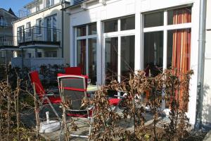 eine Terrasse mit Stühlen und einem Tisch vor einem Gebäude in der Unterkunft Haus Möwe I Whg 02 mit Terrasse in Ostseebad Sellin
