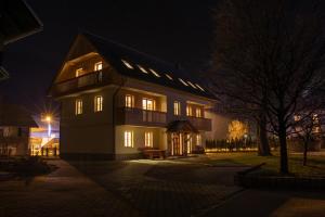 uma casa grande à noite com as luzes acesas em Apartments & Rooms Pr' Skalovc em Bohinj