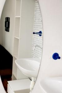 La salle de bains blanche est pourvue d'un lavabo et d'une baignoire. dans l'établissement Appartement Lefferts, à Zandvoort