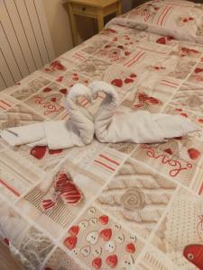 Una cama con dos cisnes hechos para parecer corazones en Bed & Breakfast Hostel H24, en Ragusa