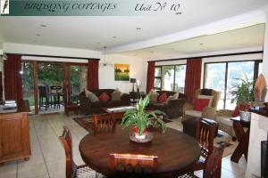 sala de estar con mesa de madera y sillas en Birdsong Cottages - 10 Poplar Drive - Bergview Estate en Champagne Valley