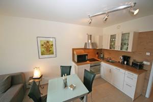 a kitchen and living room with a table and a couch at Haus Möwe Whg 02 mit Balkon & Terrasse in Thiessow