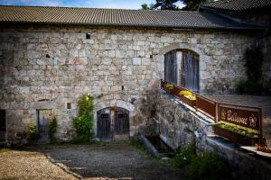 Tence的住宿－Bellevue Chambres d'hôtes，一座古老的石头建筑,设有门窗