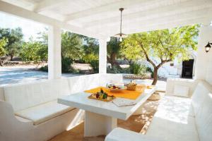 una sala da pranzo bianca con tavolo e sedie di HelloApulia - Enchanting Trulli del Mandorlo a Ceglie Messapica