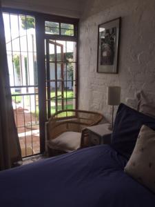 1 dormitorio con 1 cama y puerta que da a un patio en Delightful Surrey Street en Ciudad del Cabo