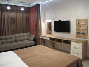 アドレルにあるApartment Na Staroobryadcheskoyのベッド1台、薄型テレビが備わるホテルルームです。