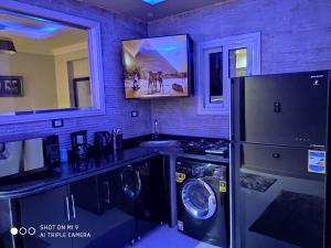 una cocina con refrigerador y lavadora y secadora en Hi Pyramids, en El Cairo 31 fotos más