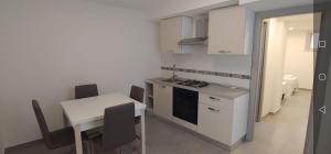 a kitchen with a table and a stove and a table and chairs at Vico Spina 5 in Milazzo