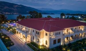 um grande edifício com um telhado vermelho numa rua em The Lake Hotel em Ioannina