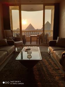 Una sala de estar con sofás y una mesa con vistas. en Hi Pyramids, en El Cairo